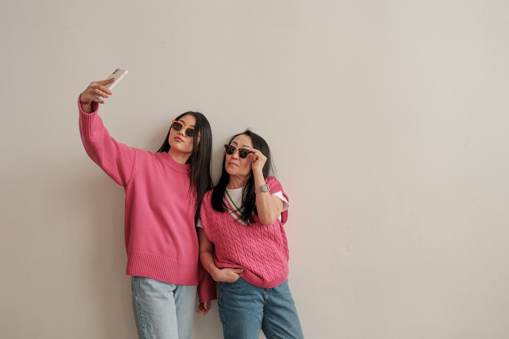 Mom and Daughter in Casual Outfits Taking Selfie Together